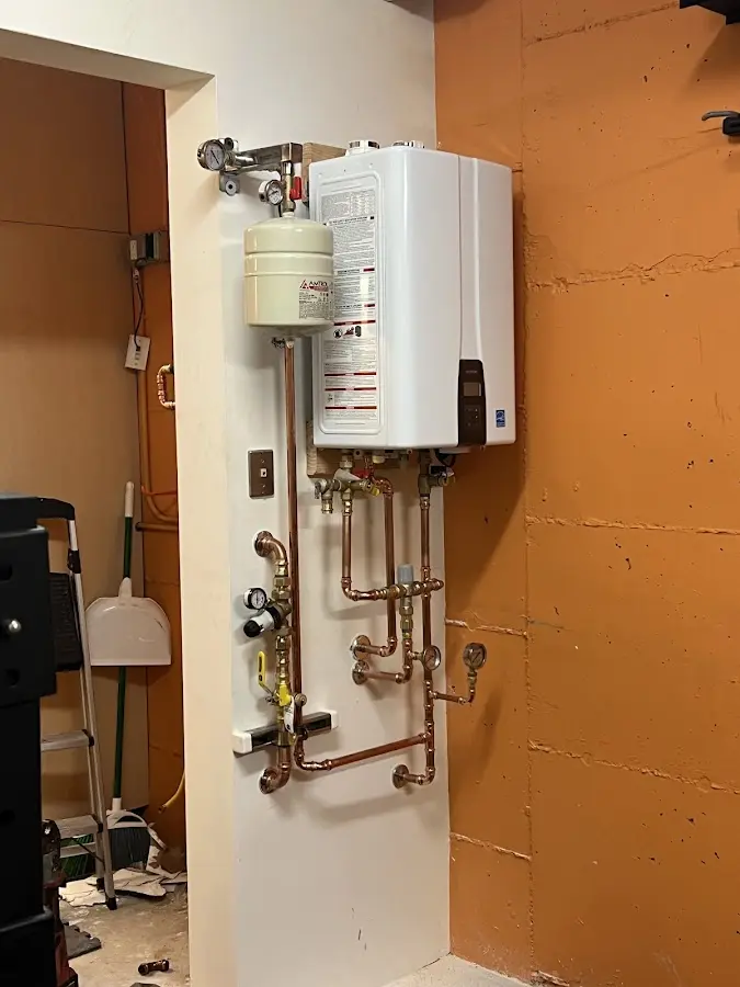 Plumbing technician inspecting water heater connections in Ripon